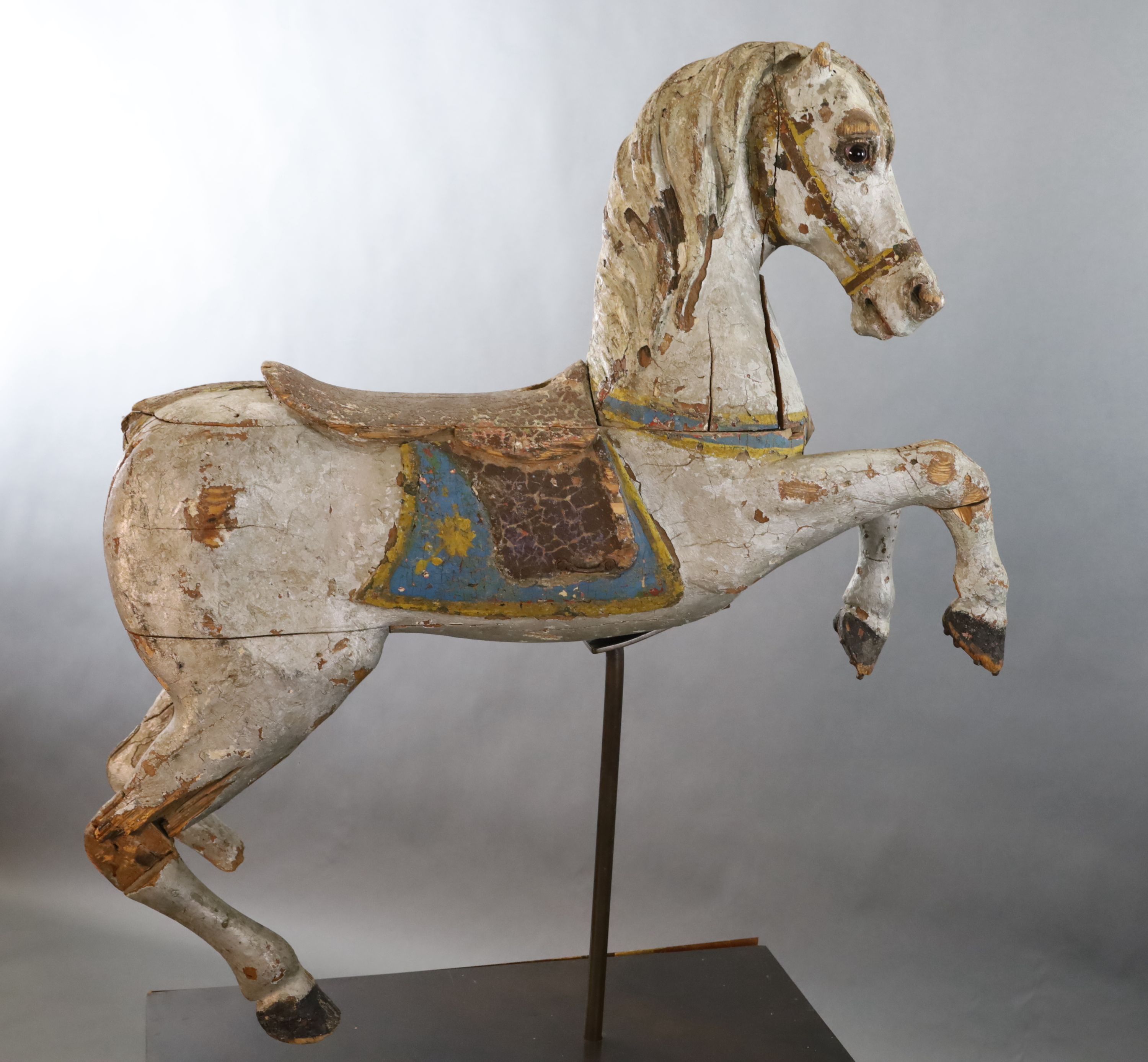 A 19th century, probably American, painted wood carousel horse, L.3ft 5in. H.3ft 7in. Overall H. when on stand 5ft 9in.